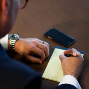 man writing on a notepad man writing on a notepad